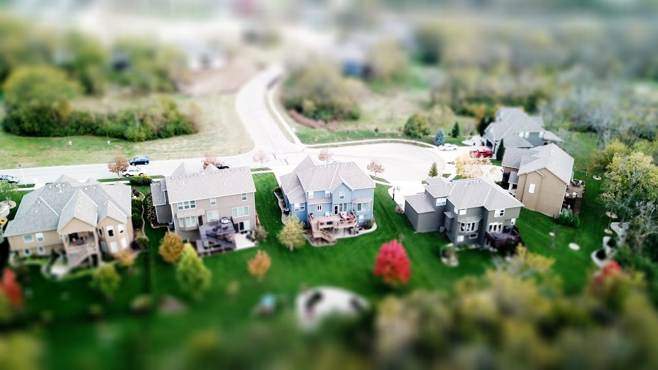 Suburban neighborhood with green lawns and colorful trees.